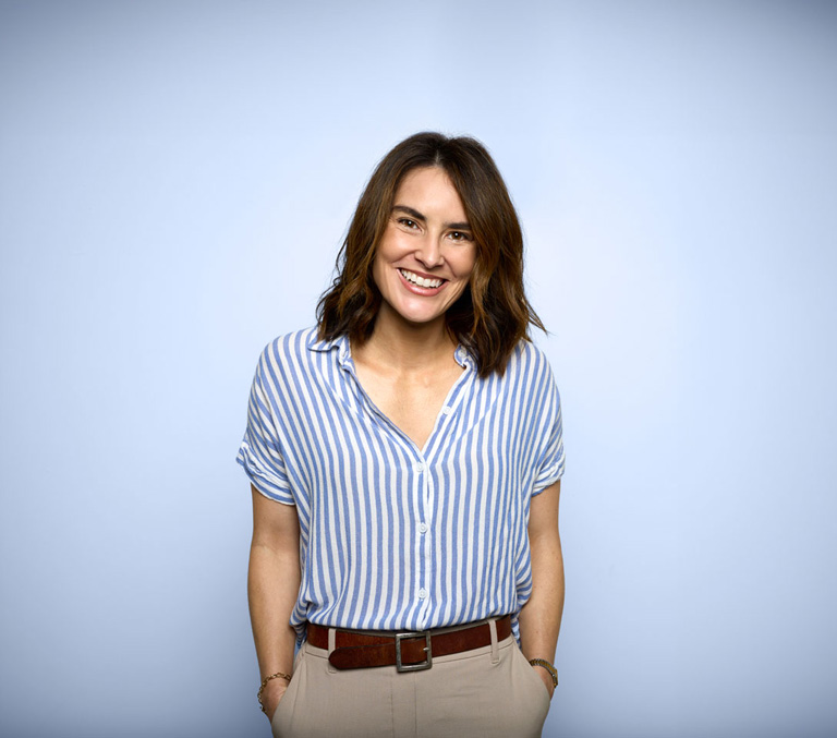 A lady smiling on a grey background