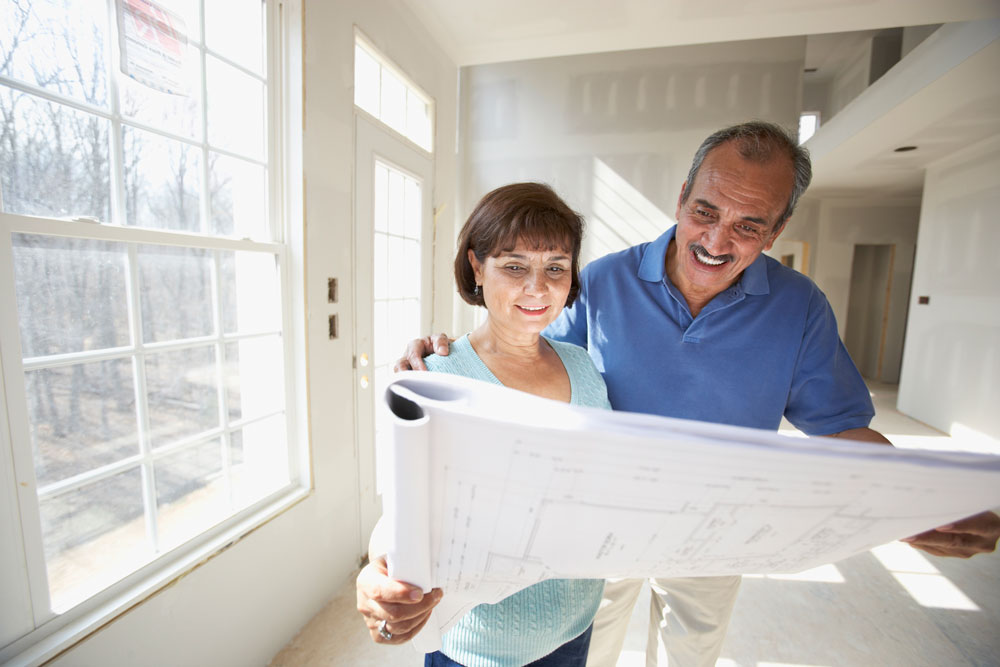 Older couple reviewing floor plans for their custom built home