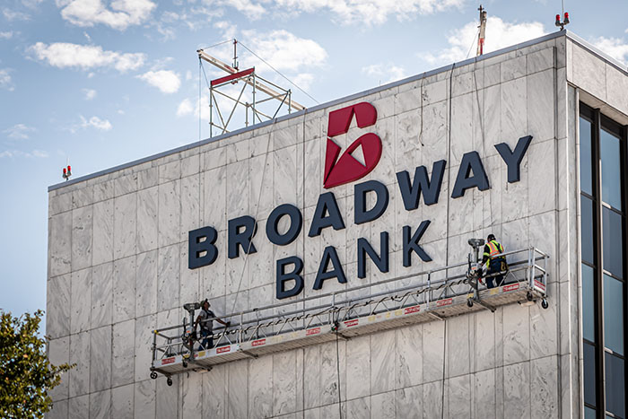 A sign being installed on the side of the Broadway Bank Headquarters