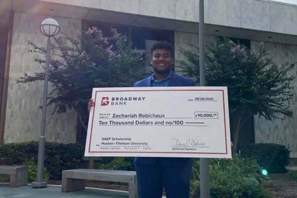 a student receives a scholarship donation from Broadway Bank