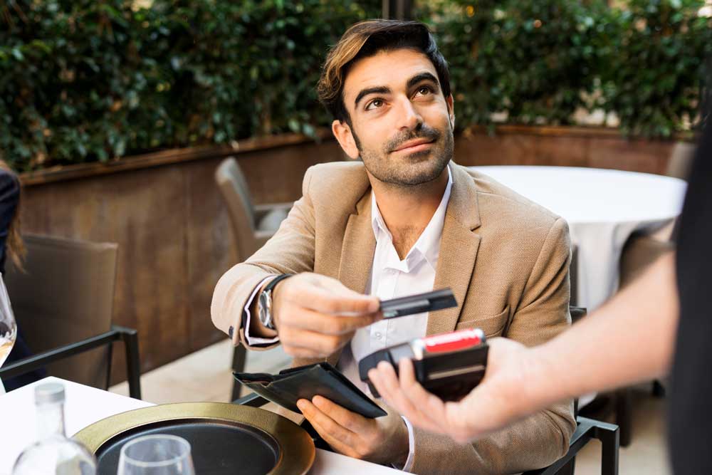 a business man pays his bill with a Broadway Bank commercial credit card