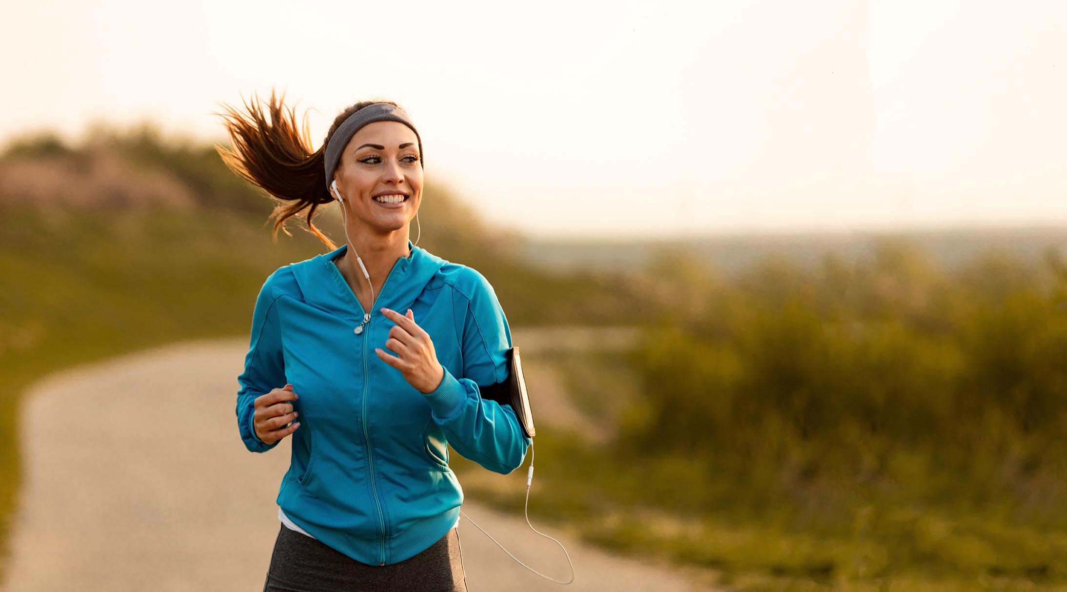 A woman jogging and smiling after being approved for a Broadway Bank personal loan