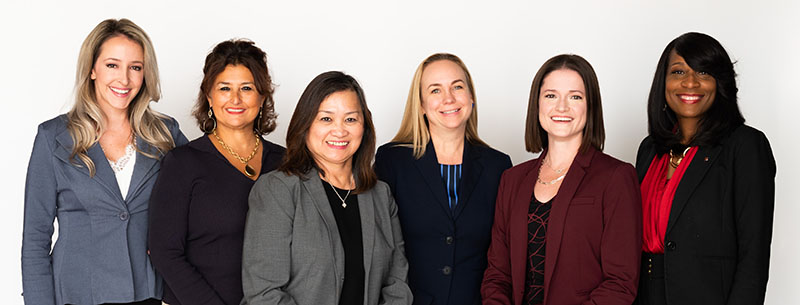 Diverse group of female bankers at Broadway Bank standing in front of a white background