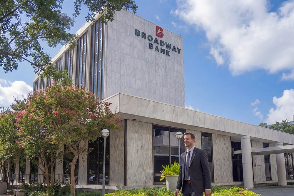 A banker walking in the Broadway Bank courtyard