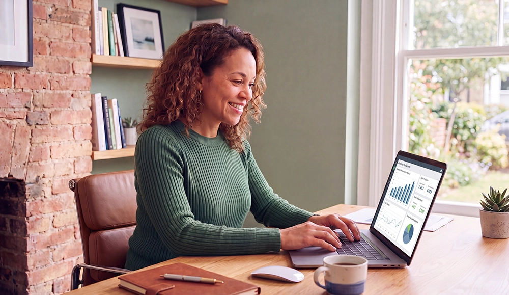 a business woman working on a computer smiling 