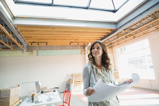 Woman looking at a blue print at a construction site