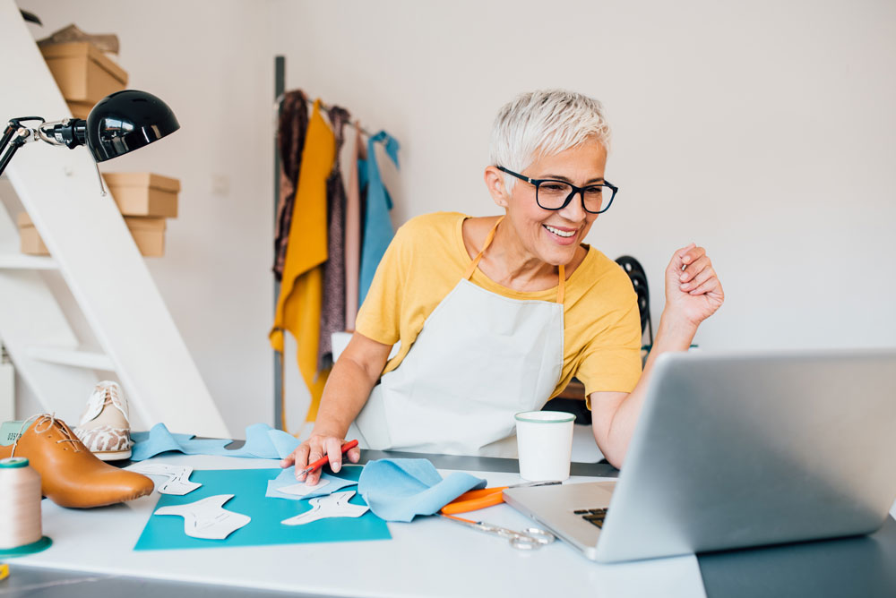A woman looking at her computer smiling