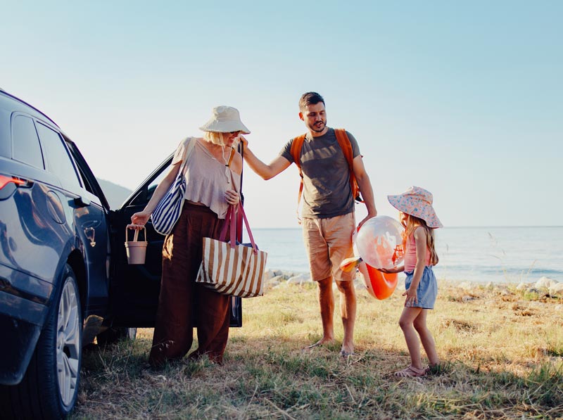 A family packing their car at the beach