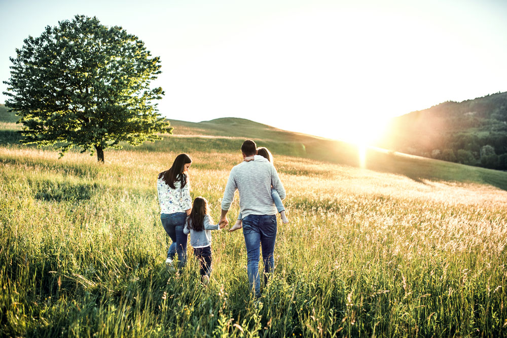 A couple with two children walking in the field