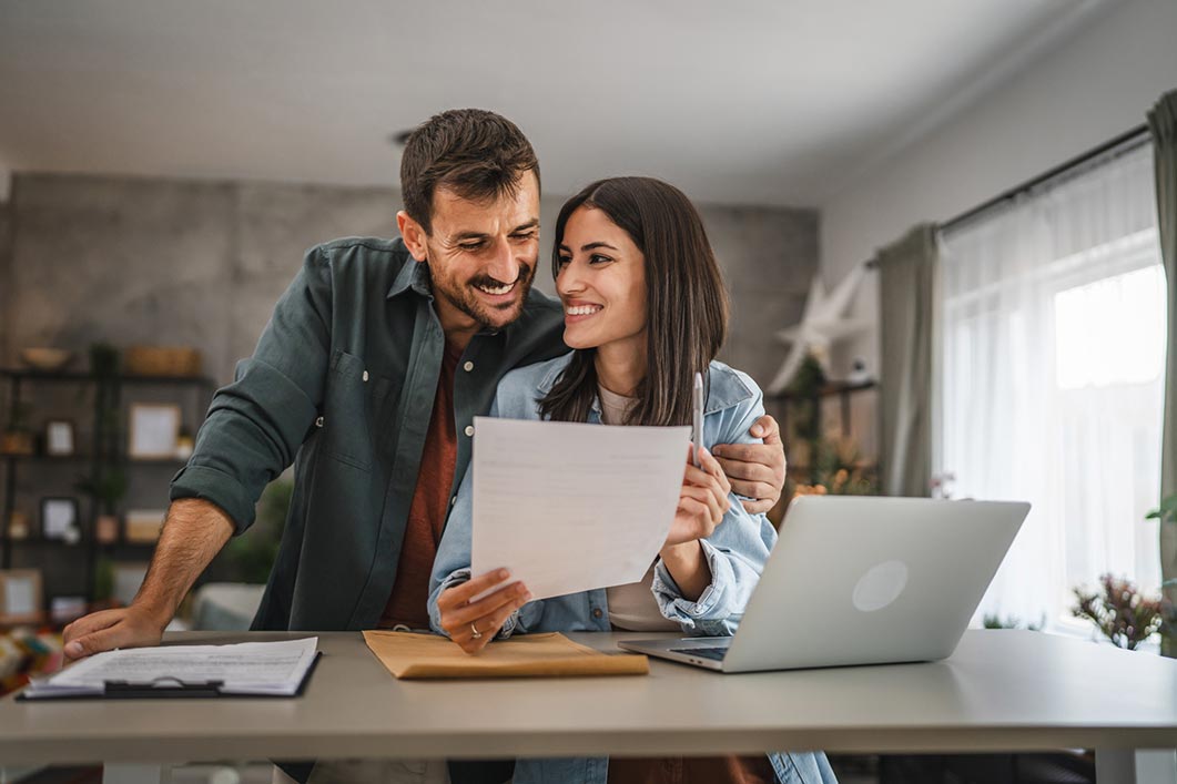 man and woman looking at paperwork smiling