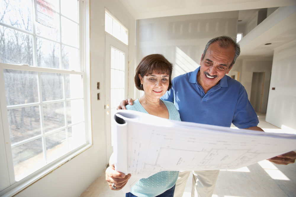 Older-couple-looking-at-floor-plans