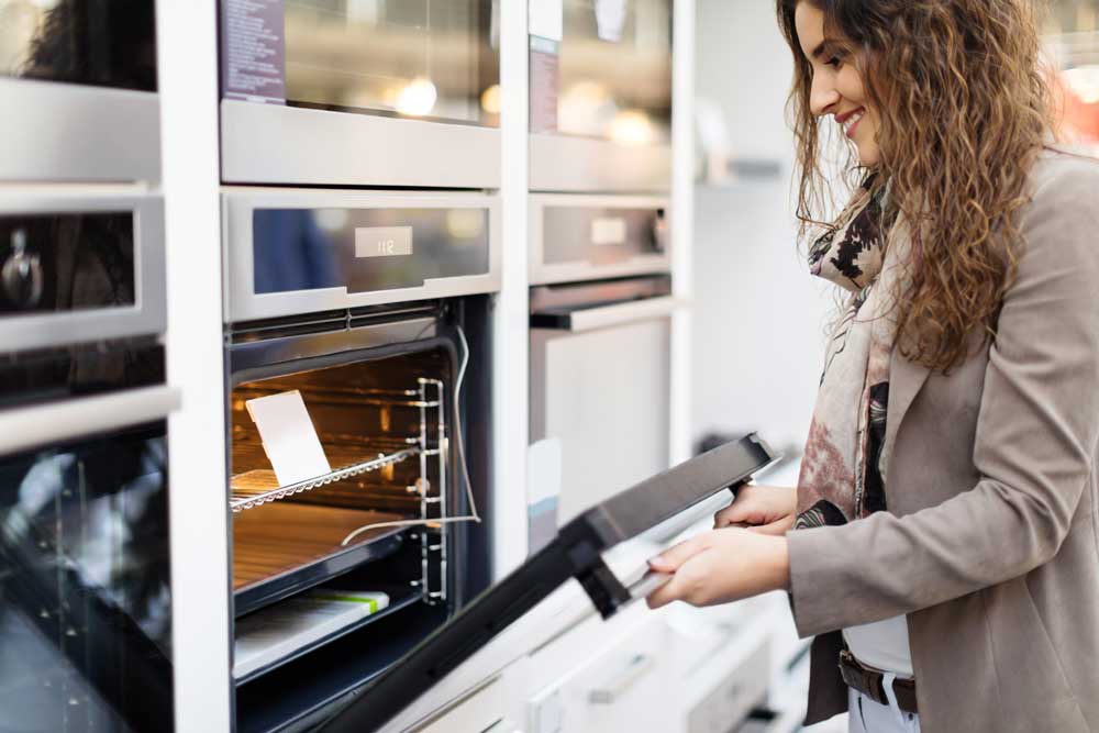 Woman looking at a stove in a store