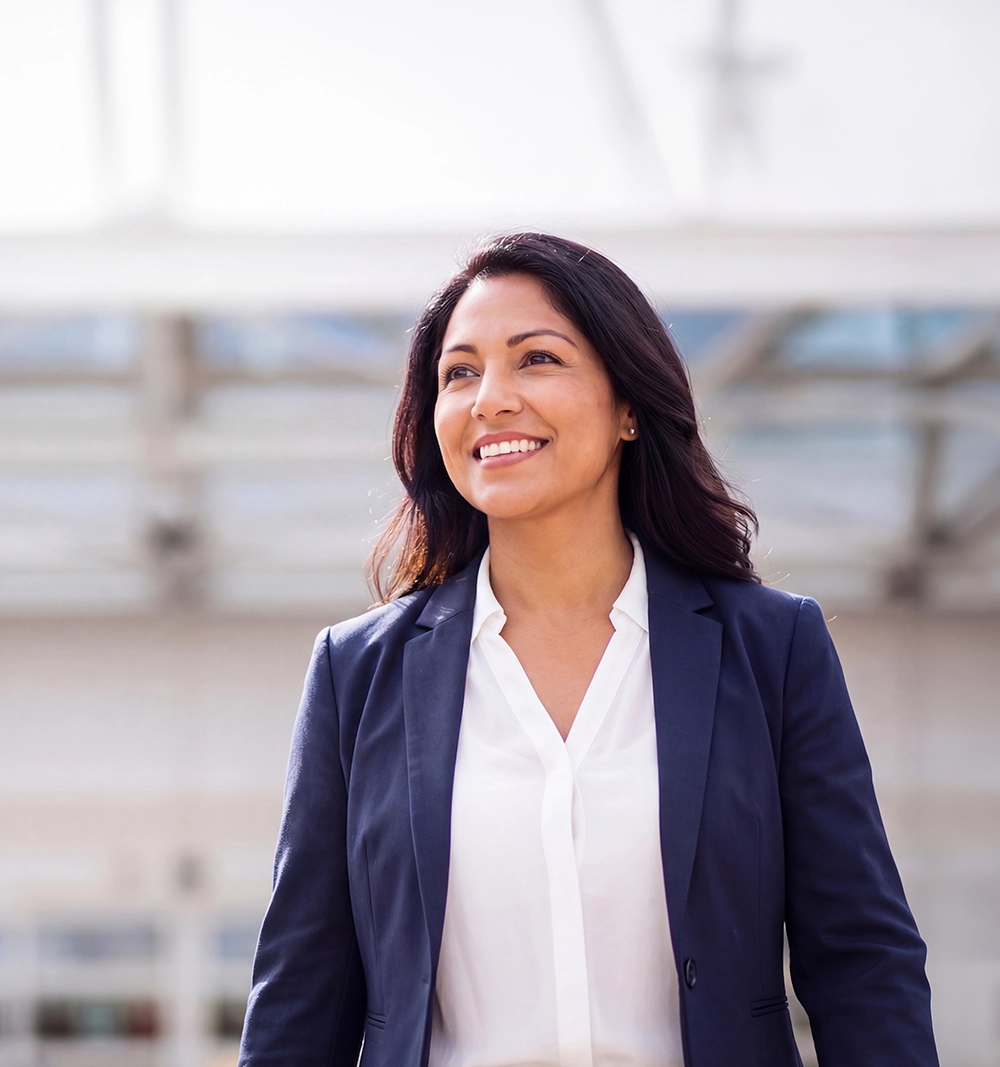 A young lady wearing a blue suit walking and smiling