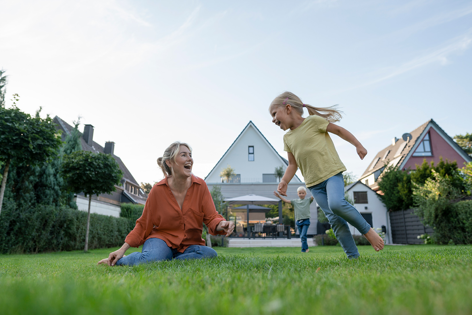 Woman playing with her daughter on a green lawn